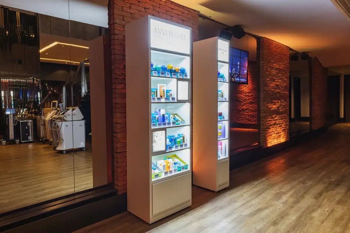 Floor-to-ceiling mirror reflecting wooden millwork and warm lighting in a narrow retail space, creating depth illusion