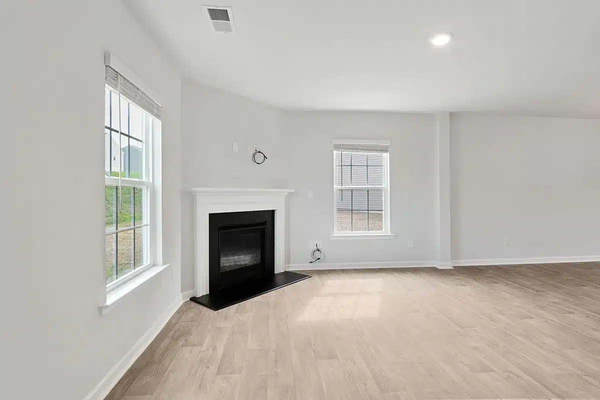 Interiores minimalistas con paredes de yeso gris claro y chimenea de piso a techo