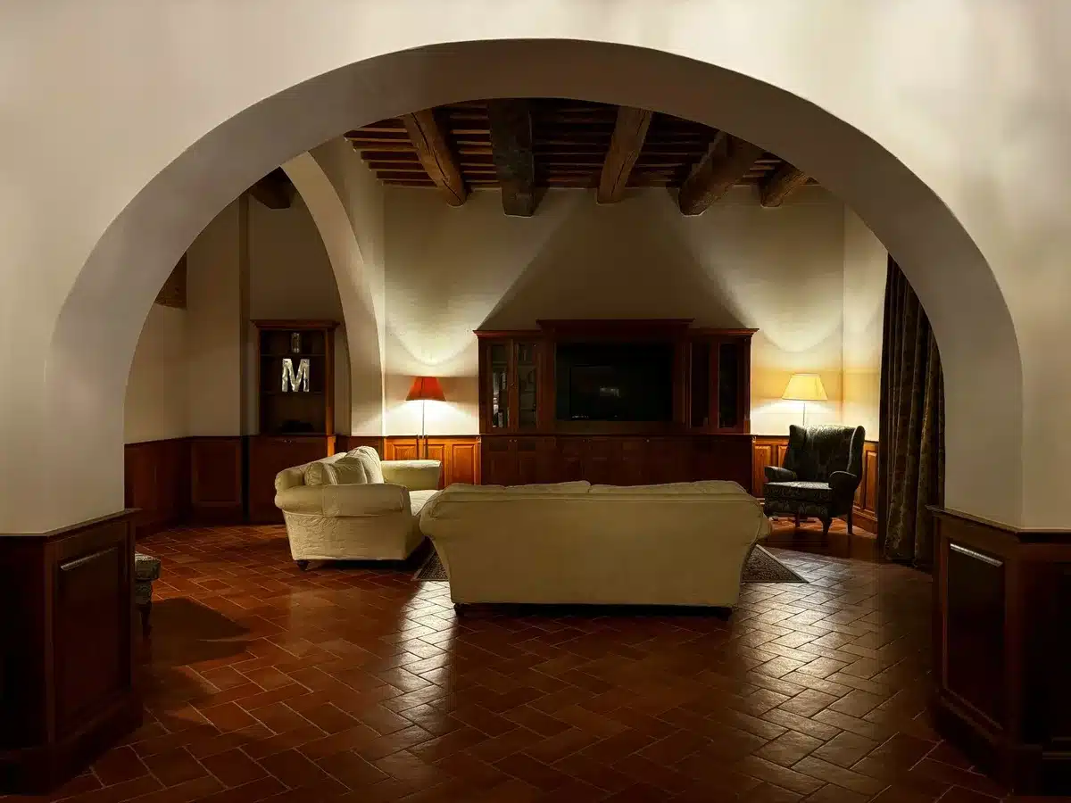 Sala de estar Toscana con chimenea prominente, sofás de lino belga y decoración rústica