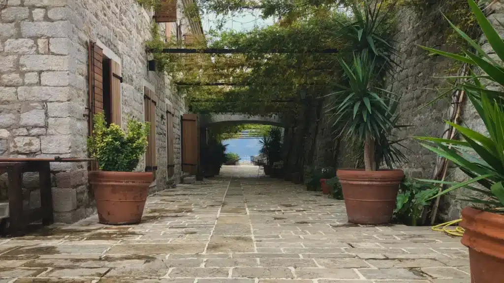 Elegante patio con piscina central rodeada de plantas aromáticas y arquitectura Toscana