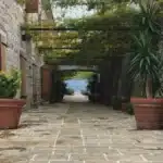 Elegante patio con piscina central rodeada de plantas aromáticas y arquitectura Toscana