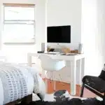 Modern minimalist apartment interior with bright natural light, wooden floors, and neutral furnishings