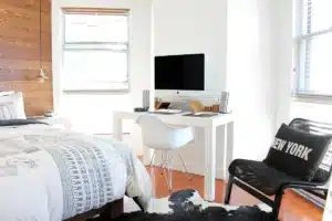 Modern minimalist apartment interior with bright natural light, wooden floors, and neutral furnishings